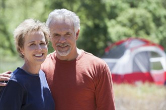 Senior Caucasian couple smiling at campsite