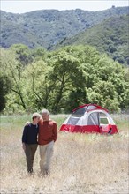Senior Caucasian couple walking in rural field