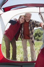 Senior Caucasian couple peering into tent