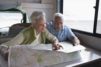 Mixed race Senior couple reading map in RV