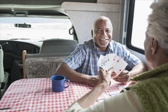Mixed race Senior couple playing cards in RV