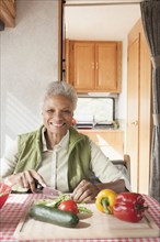 Mixed race Senior woman cooking in RV