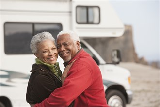 Mixed race Senior couple hugging by RV