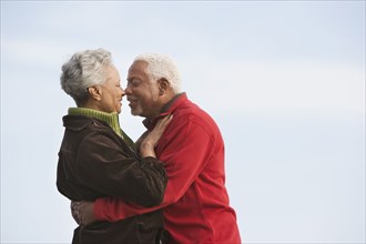 Mixed race Senior couple kissing outdoors