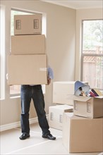 Hispanic man with cardboard boxes in new home