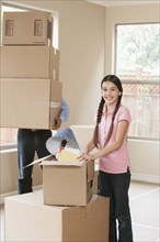 Hispanic father and daughter unpacking in new home