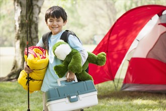 Asian boy carrying camping gear