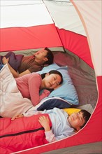 Asian family sleeping in tent