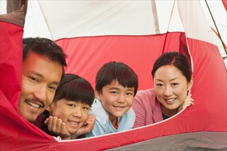 Family relaxing together in tent