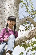 Chinese girl smiling in tree