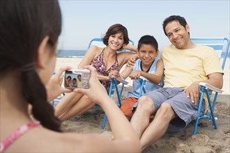 Family taking pictures together on beach