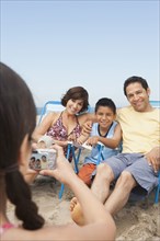 Family taking pictures together on beach