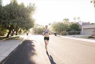 Caucasian woman running in suburban street