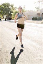 Caucasian woman running in suburban street