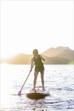 Caucasian woman on paddleboard in river