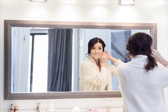 Reflection of Caucasian woman in bathroom mirror