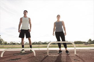 Couple standing nears exercise bars outdoors
