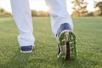 Grass sticking to shoe of golfer