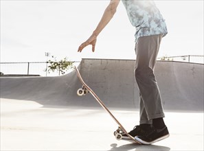 Hispanic man stepping on tail of skateboard