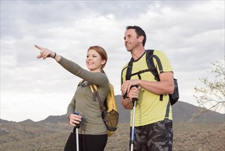 Woman pointing to man in desert while hiking