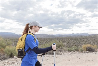 Caucasian woman hiking on rocky path in desert