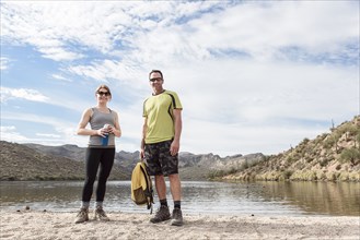 Portrait of smiling hikers standing at lake