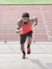 African American man running on bleachers