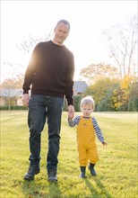 Caucasian father and son walking in field