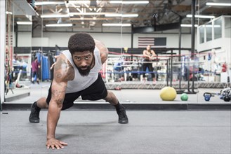 Black man doing push-up in gymnasium