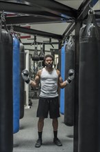 Serious black boxer posing in gymnasium