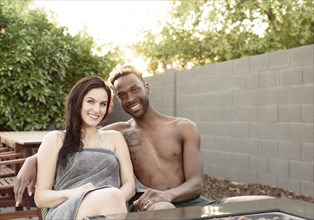 Portrait of smiling couple wrapped in towels near fire pit
