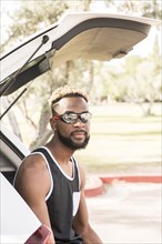 Portrait of Black man wearing sunglasses in car hatchback