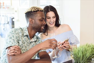 Couple drinking champagne and texting on cell phone