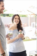 Smiling Caucasian couple holding cold drinks outdoors