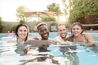 Portrait of smiling friends in swimming pool