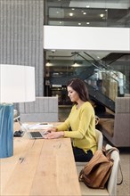 Caucasian woman using laptop at table