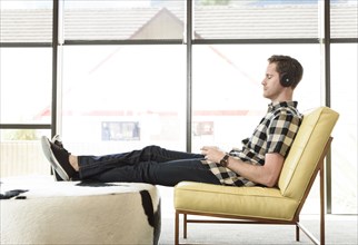 Caucasian man relaxing and listening to headphones