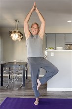 Caucasian man practicing yoga in home