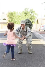 Black woman soldier greeting daughter in street