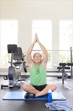 Caucasian man practicing yoga in gymnasium