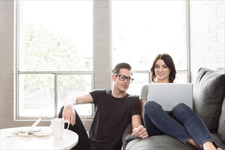Caucasian couple using laptop on sofa