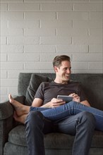 Legs of Caucasian woman on lap of man using digital tablet