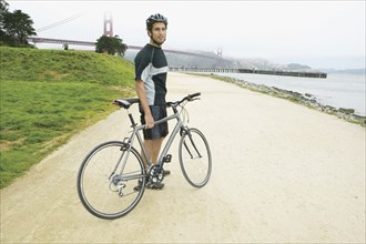 Portrait of man with bike with Golden Gate Bridge behind him
