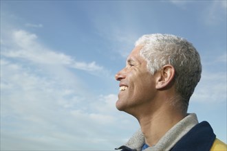 Profile of middle-aged man under blue sky