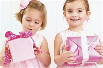 Young girls holding wrapped presents