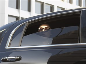 Asian woman in limousine with window part of the way down