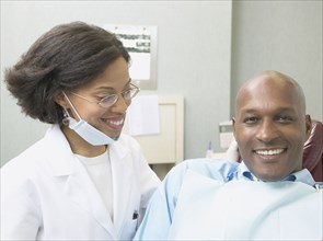 African female dentist with male patient
