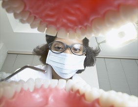 Shot from mouth looking out at African female dentist
