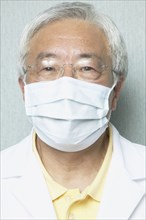 Senior Asian male dentist wearing surgical mask
