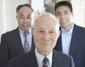 Senior Asian man with family members in background